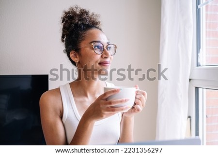 African American woman enjoying tea near window