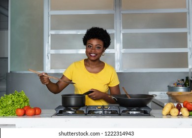 African american woman  enjoys cooking healthy food at kitchen