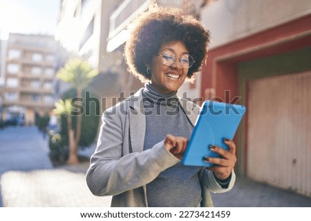 African american woman executive smiling confident using touchpad at street