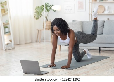 African american woman exercising with online tutorial on laptop at home, empty space - Powered by Shutterstock