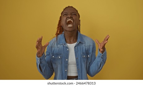 African american woman expressing frustration or anger against a solid yellow background, wearing a denim jacket. - Powered by Shutterstock