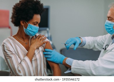 African American Woman Getting A Vaccine At The Doctors Office.