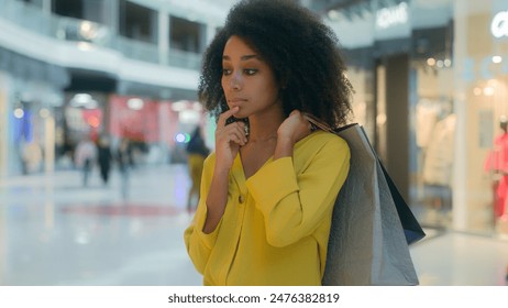 African American woman going walk shopping mall buyer client holding packages think choose pensive reflect girl thoughtful female shopper spend new clothes consumer customer discount price shopaholic
