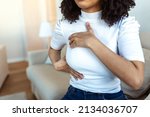 African American Woman hand checking lumps on her breast for signs of breast cancer. woman is suffering from pain in the breast. BSE or Breast Self-Exam. Guidelines to check for cancer.
