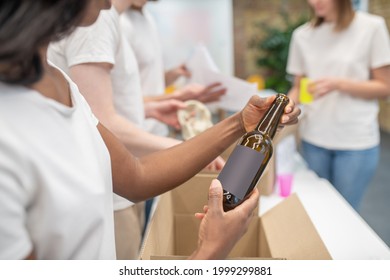 African American Woman Hands Holding Bottle Over Box