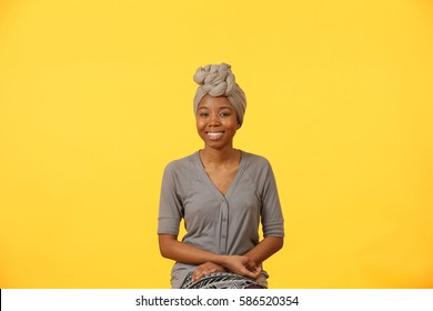 African American Woman With Head Wrap On Yellow Background.
