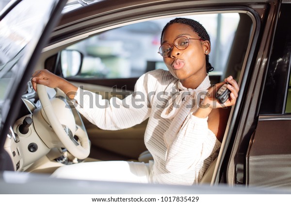 african\
american woman with her new car showing\
key