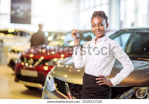 african\
american woman with her new car showing\
key