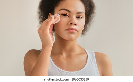 African American Woman Holding Cotton Pad Disk Cleaning Face Skin With Cleanser Tonic. Skin Care Remove Make Up Purify Lotion Or Micellar Water.