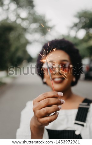 An african american woman holding a sparkler