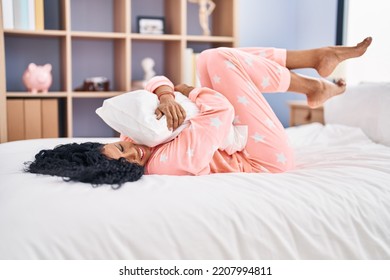 African American Woman Hugging Pillow Lying On Bed At Bedroom