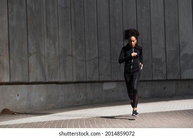 African American Woman Jogging On Urban Street