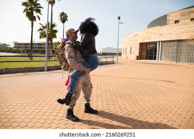 An african american woman jumps on her soldier boyfriend who has come home from the war. They are going to melt in a loving embrace and look at each other with passion and emotion. Concept war, army. - Powered by Shutterstock