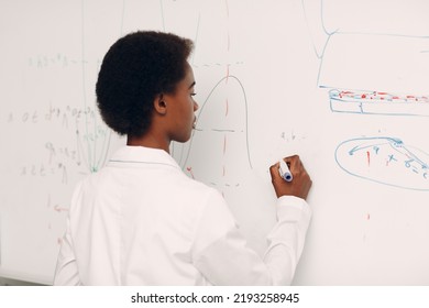 African American Woman Math Student Writing On Blackboard With Marker.