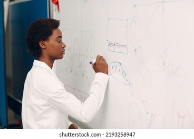 African American Woman Math Student Writing On Blackboard With Marker.