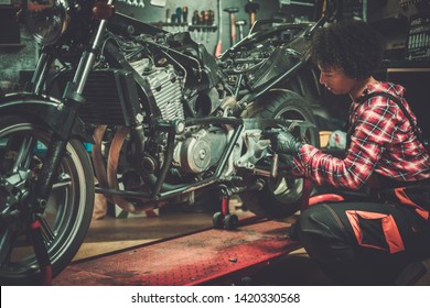 African American Woman Mechanic Repairing A Motorcycle In A Workshop