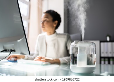 African American Woman In Office With Air Humidifier