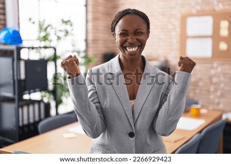African american woman at the office very happy and excited doing winner gesture with arms raised, smiling and screaming for success. celebration concept.  Foto d'archivio © 