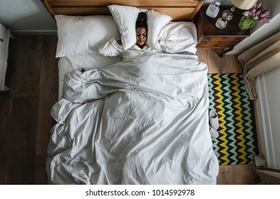 African American woman on bed insomnia and noise pollution concept