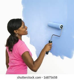 African American Woman Painting Wall Blue.