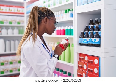 African American Woman Pharmacist Reading Medication Label Bottle At Pharmacy