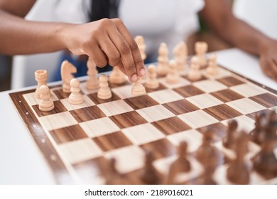 African American Woman Playing Chess Game Sitting On Table At Home