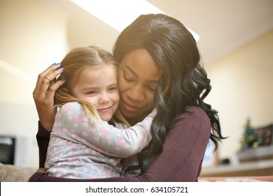 African American woman playing with girl. Woman hugging her adopted daughter.