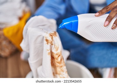 African American Woman Pouring Detergent On Dirty T Shirt At Laundry Room