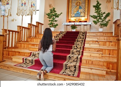 African american woman praying in the church. Believers meditates in the cathedral and spiritual time of prayer. Afro girl hold rosary and kneeling.