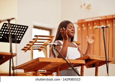 African american woman praying in the church. Believers meditates in the cathedral and spiritual time of prayer. Afro girl singing and glorifying God on choruses.