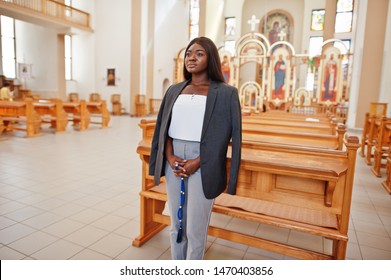 African american woman praying in the church. Believers meditates in the cathedral and spiritual time of prayer. Afro girl with rosary on hands.