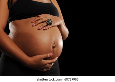 African American Woman pregnant against a black background