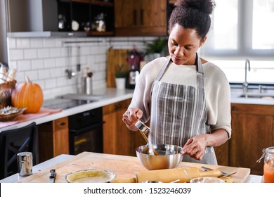 African american woman preparing pumpkin pie for holidays - Powered by Shutterstock