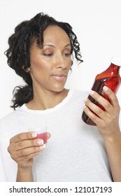 African American Woman Reading A Bottle Label Of Medicine