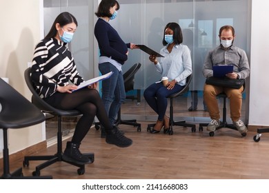 African American Woman Receiving Job Offer From Financial Department Pregnant Manager In Waiting Room. Diverse Candidates In Lobby Area Reading Company Internal Regulations.