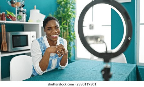 African american woman recording online tutorial for social networks at dinning room - Shutterstock ID 2330119301