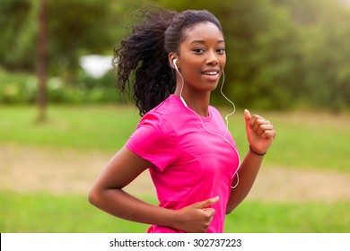 African american woman runner jogging outdoors - Fitness, people and healthy lifestyle - Powered by Shutterstock