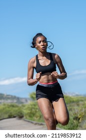 African American Woman Running Fast Along A Wooden Runway: Exercise Concept.