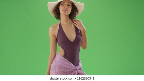 African American woman in sarong and bathing suit and sun hat on green screen - Powered by Shutterstock