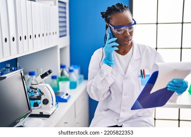 African American Woman Scientist Reading Document At Laboratory