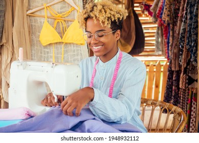 African American Woman Sewing A Stylish Yellow Swimming Suit For Summer Pool Party In Tropical Workshop In Bali