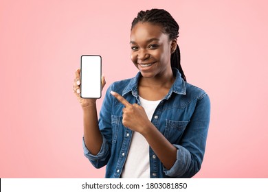 African American Woman Showing Cellphone Blank Screen Smiling To Camera Posing Over Pink Background. Studio Shot, Mockup