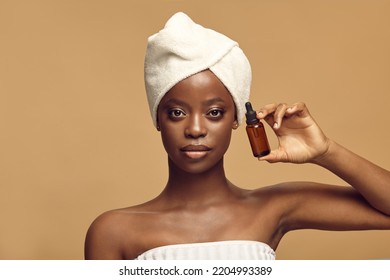 African American Woman Shows Small Cosmetic Bottle.