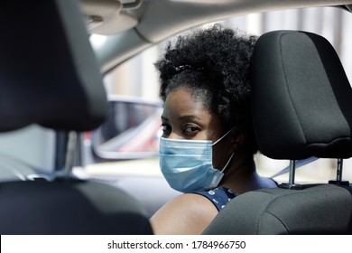 African American Woman Sitting In Car Front Seat Wearing Protective Face Mask