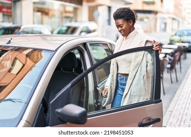 African american woman smiling confident opening car door at street