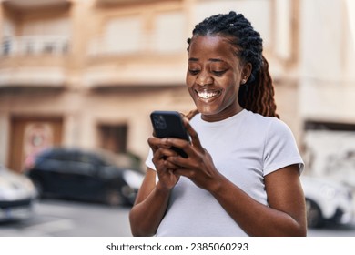 African american woman smiling confident using smartphone at street - Powered by Shutterstock