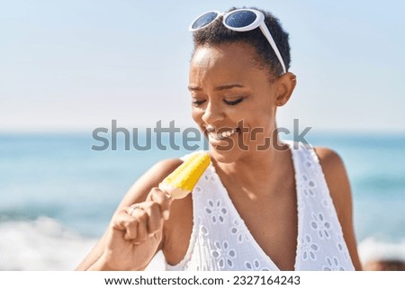 African american woman smiling confident eating ice cream at seaside