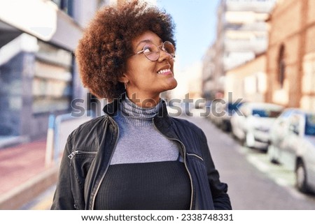 African american woman smiling confident looking to the sky at street