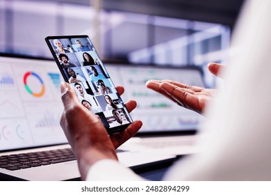 African American woman smiling while analyzing data on laptop in smart webinar, discussing KPI charts via videoconference. - Powered by Shutterstock