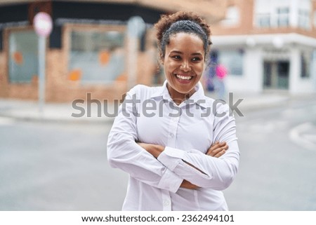 African american woman standing with arms crossed gesture at street